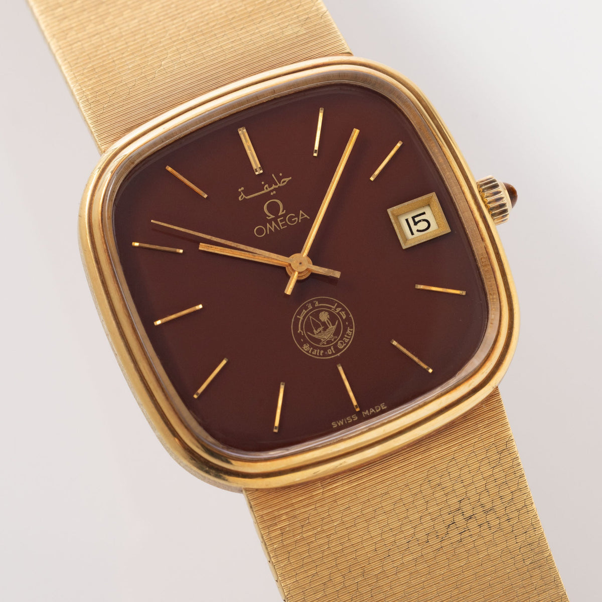 Omega "State of Qatar" Squared Dresswatch Oxblood Stella-esque Dial from Original Owner Family in 18k yellow Gold with integrated Woven Bracelet 
